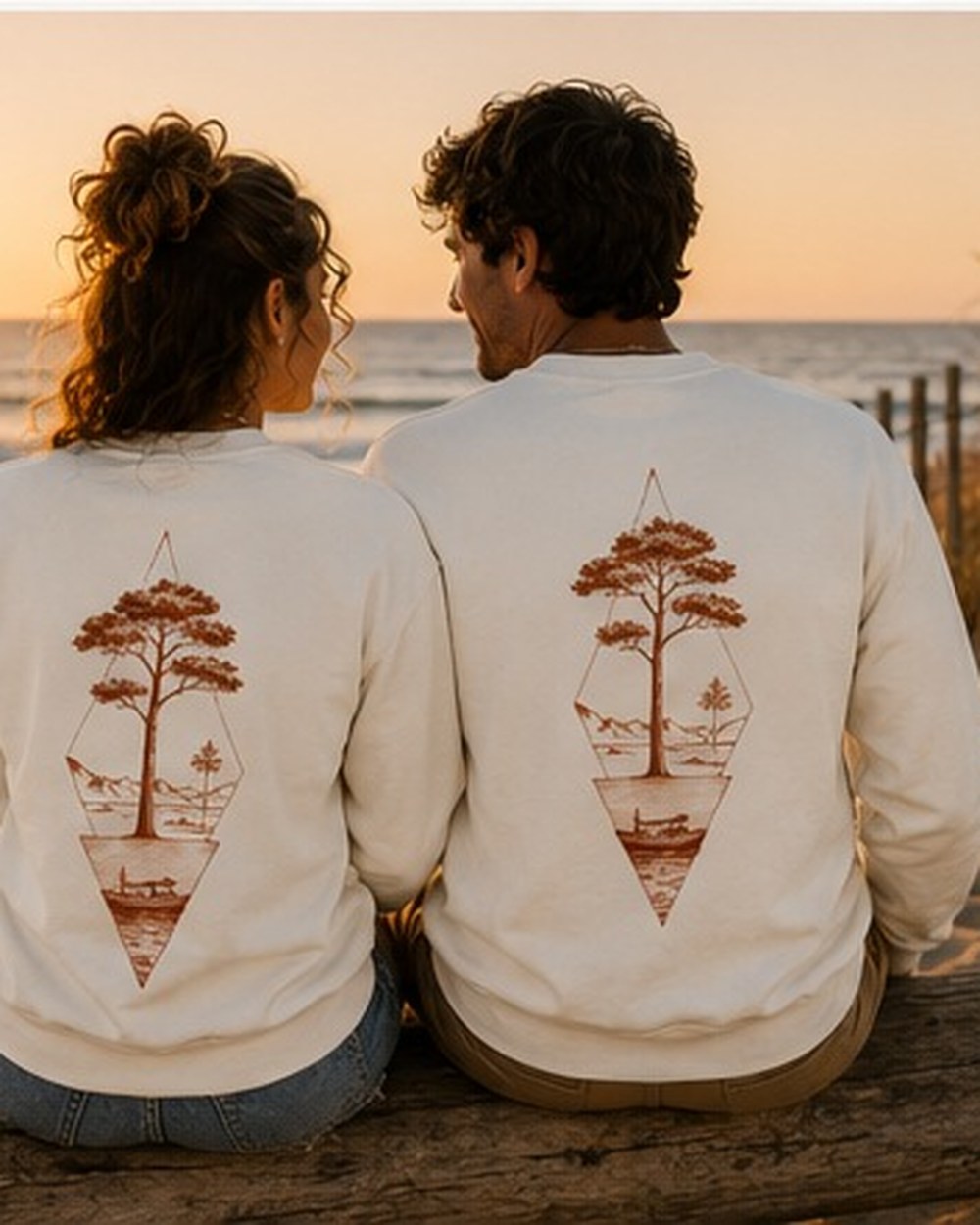 Pull Écume & Soleil motif Île & Pins beige, plié sur le sable