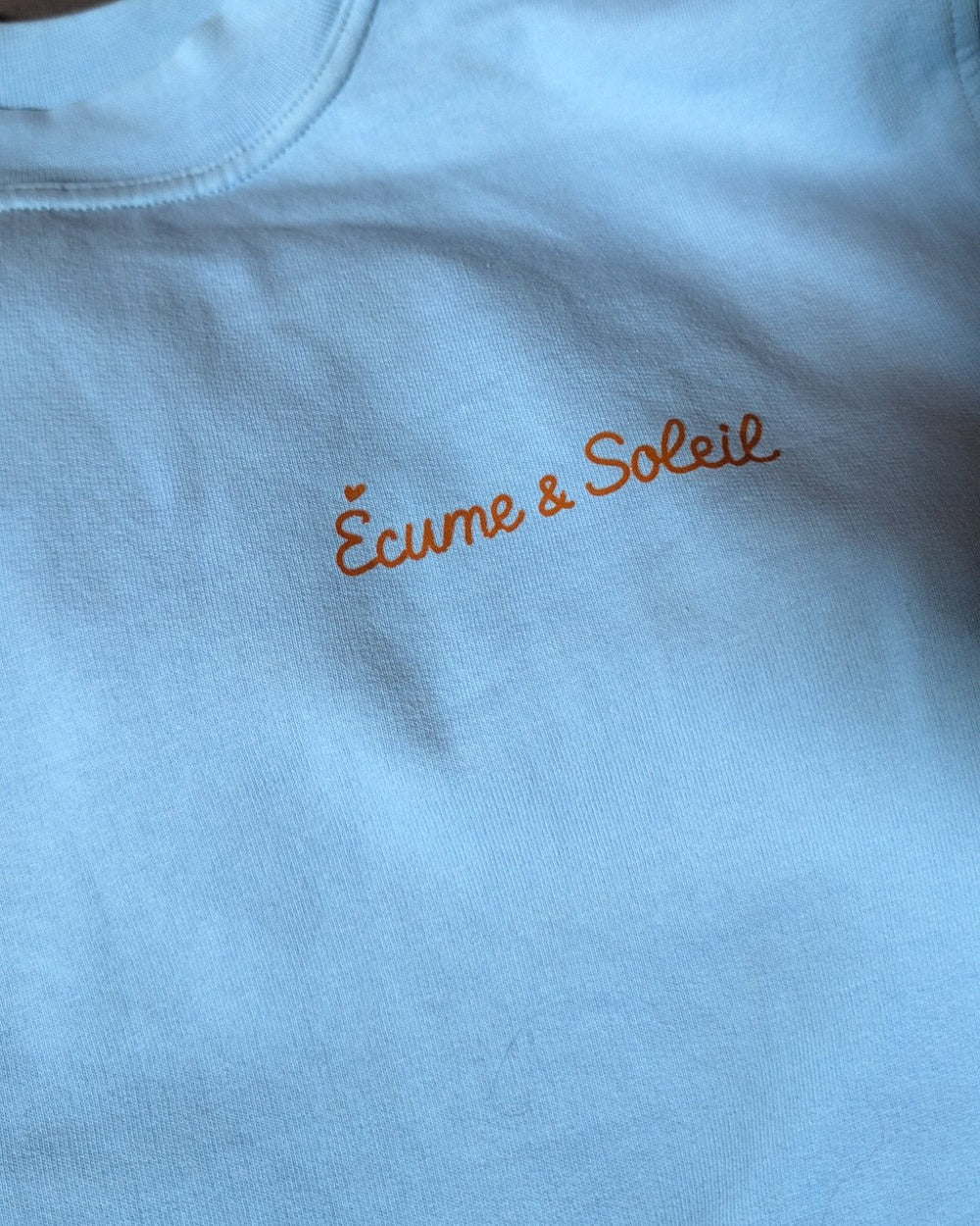 Pull Le Basique bleu ciel, détail de la signature au cœur