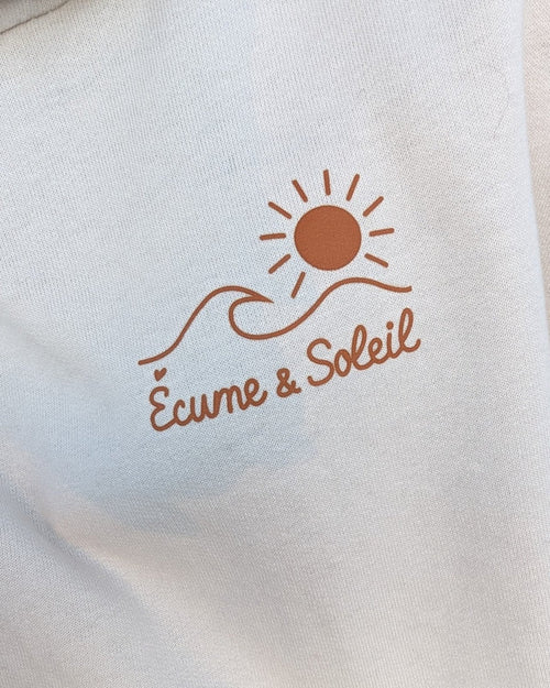 Sweat à capuche écru, logo Écume & Soleil soleil et vague marqué au cœur