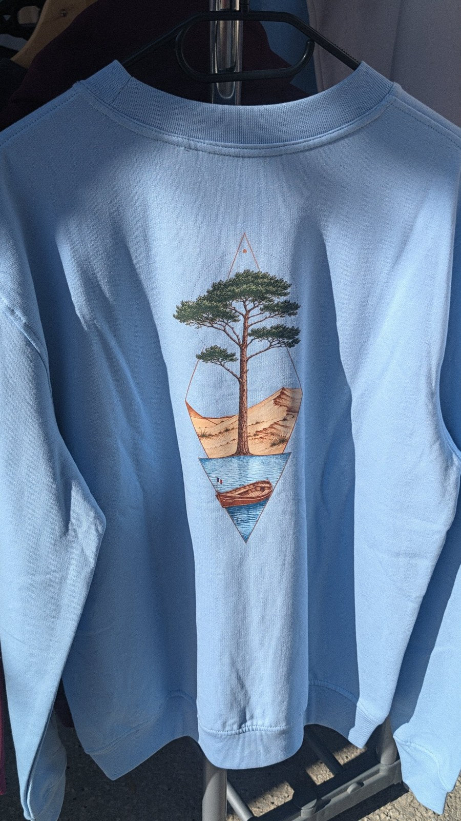 Sweat Île & Pins Couleur bleu ciel vu de dos : pin, dune et pinasse en couleurs