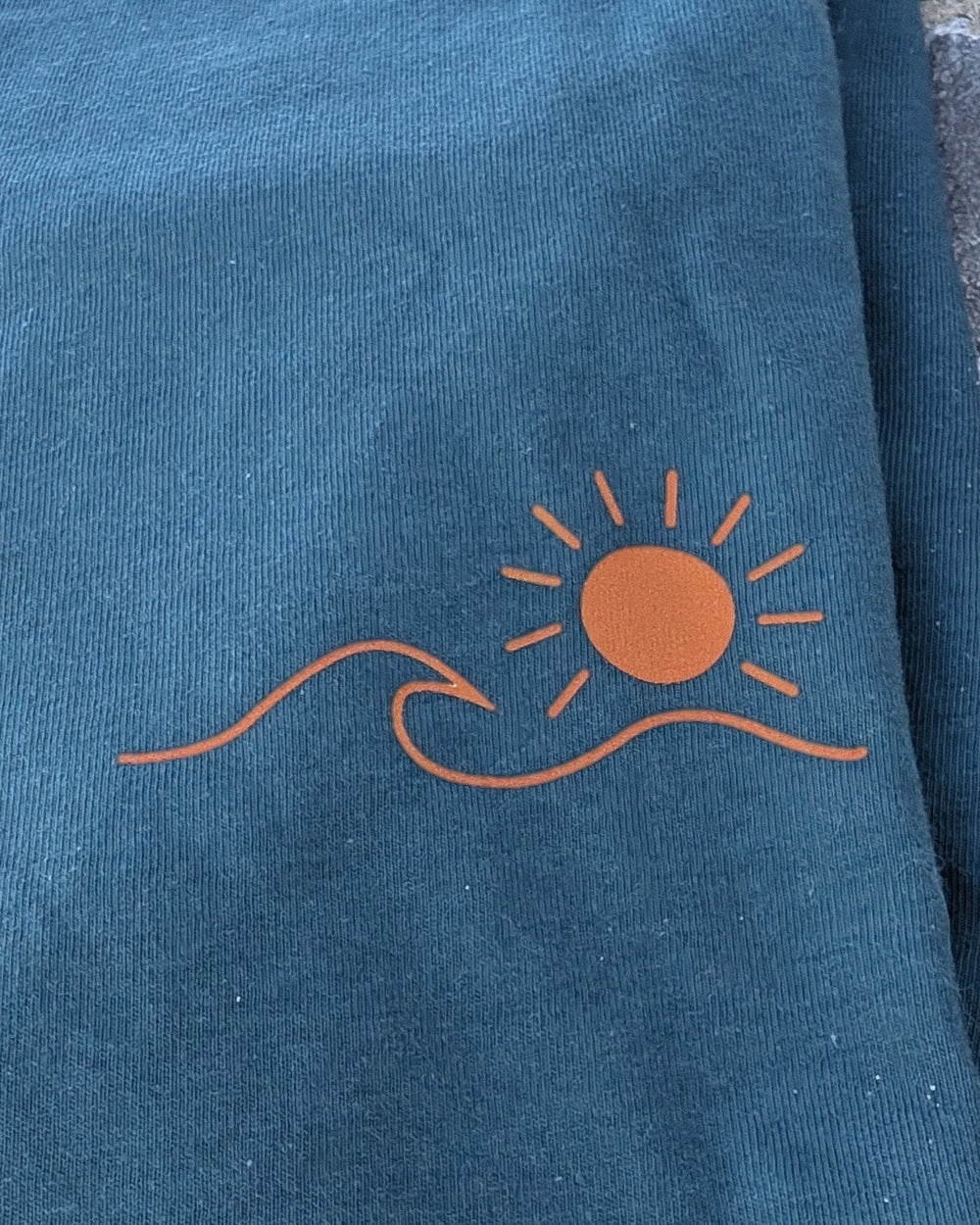 T-shirt Esprit Bassin bleu vert, gros plan du logo soleil & vague marqué