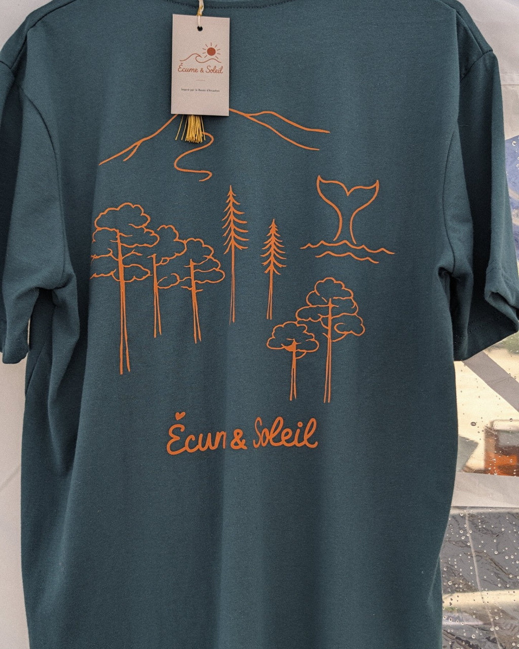 T-shirt Écume & Soleil Esprit Bassin bleu vert, vu de dos : forêt de pins, dune et queue de baleine marqués en orange