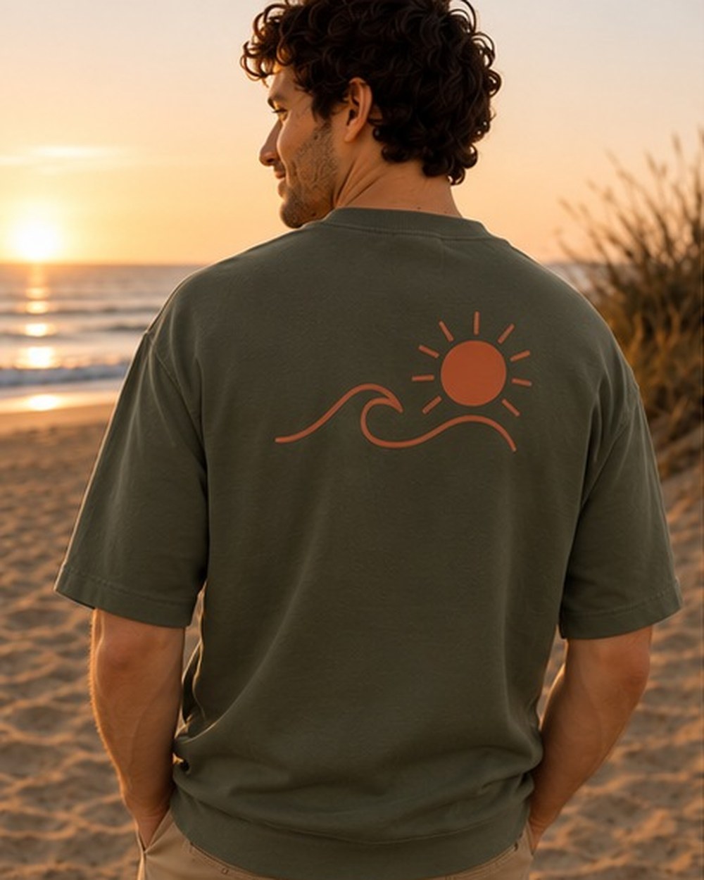 T-shirt Écume & Soleil motif Le Basique, coloris kaki, porté de dos face à l'océan