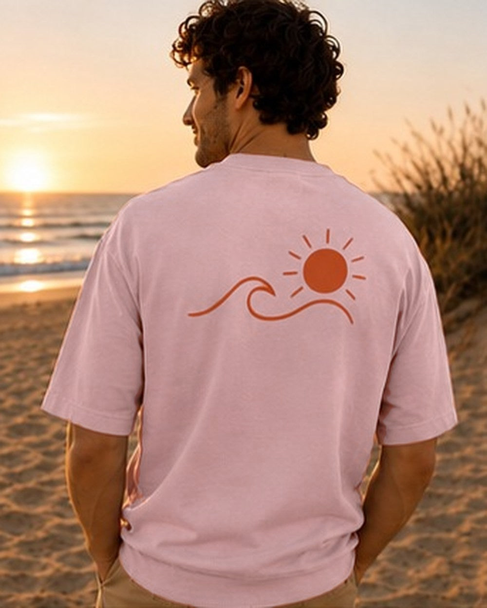 T-shirt Écume & Soleil motif Le Basique, coloris rose, porté de dos au coucher du soleil